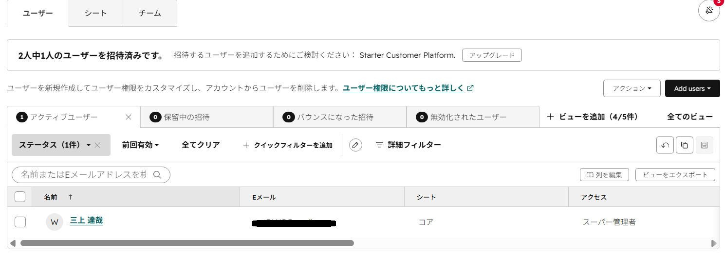 HubSpotの「ユーザーとチーム」画面。2人中1人を招待済みと表示され、シート列にコアと表示されている。